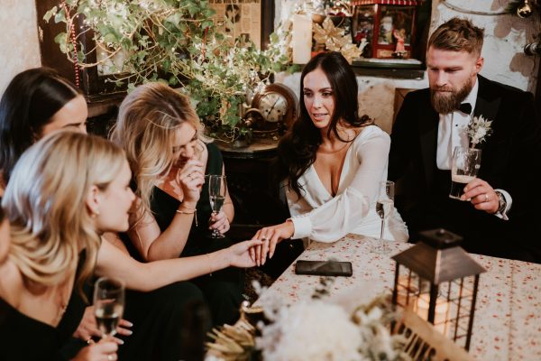 Bride showing her wedding ring to bridesmaids while celebrating inside Johnnie Fox’s