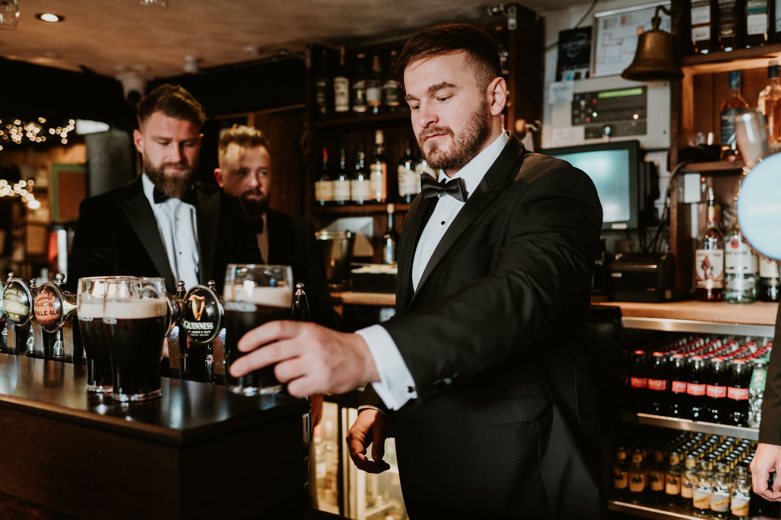 Groom pouring a pint of Guinness behind the bar during a wedding at Johnnie Fox’s Groom pouring a pint of Guinness behind the bar during a wedding at Johnnie Fox’s