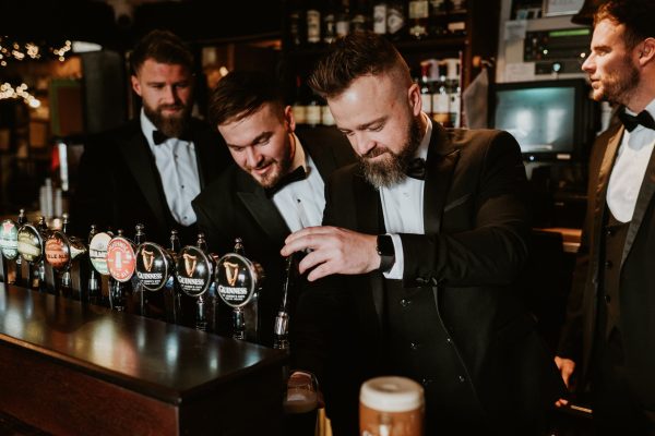 Groom pouring a pint of Guinness behind the bar during a wedding at Johnnie Fox’s