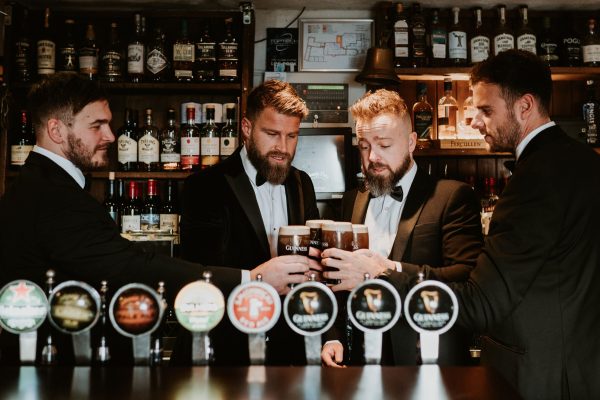 Groomsmen gathered at the bar inside Johnnie Fox’s Pub, toasting with pints of Guinness.