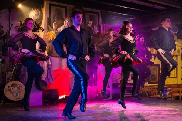 Irish dancers performing on stage at Johnnie Fox’s, dressed in traditional costumes under stage lighting.