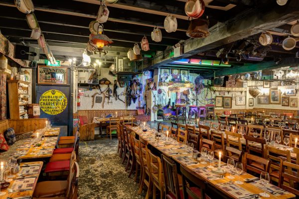 Hooley Room dining area at Johnnie Fox’s with long banquet tables, candlelight and rustic Irish décor.