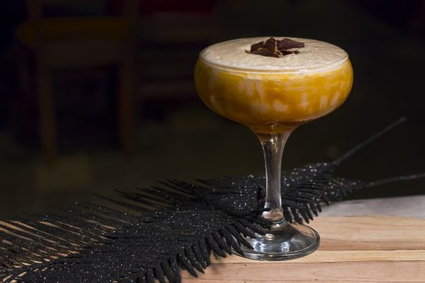 Creamy cocktail served in a coupe glass with chocolate garnish