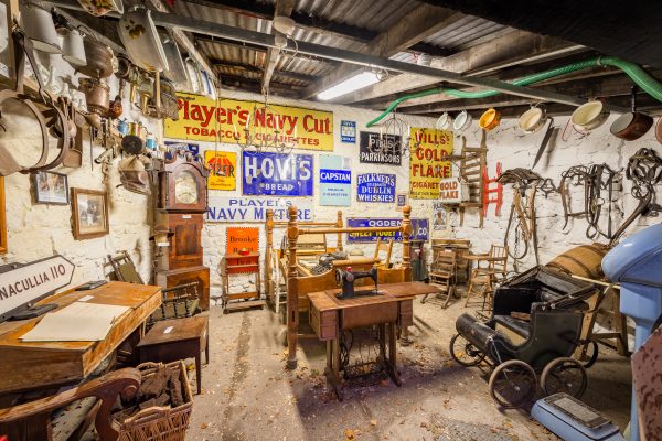 Vintage museum-style room displaying antique signs, farm tools, clocks and memorabilia at Johnnie Fox’s.