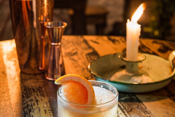 Grapefruit whiskey sour cocktail with fresh grapefruit garnish on rustic wooden bar at Johnnie Fox’s.
