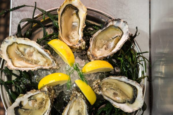 Fresh oysters on ice with lemon wedges and seaweed garnish at Johnnie Fox’s