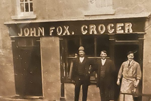 Vintage photo of three men outside John Fox Grocer, early 1900s storefront in Glencullen.