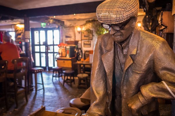 Bronze statue of Pete inside Johnnie Fox’s pub with rustic interior in the background
